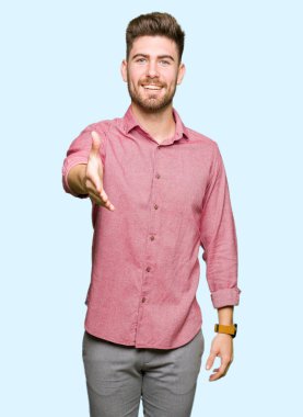 Tebrik ve konuksever dost sunan karşılıklı gülümseyen genç yakışıklı iş casual adam. Başarılı iş.