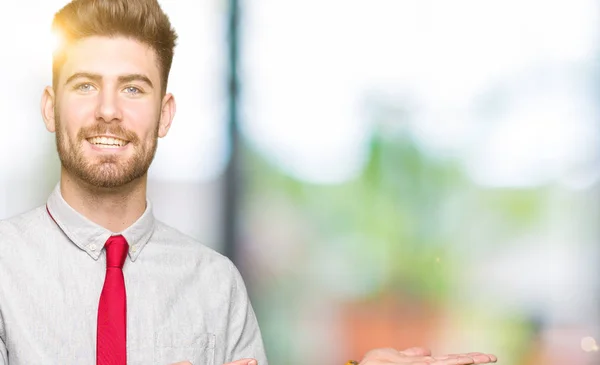 Joven Hombre Negocios Guapo Sorprendido Sonriendo Cámara Mientras Presenta Con —  Fotos de Stock