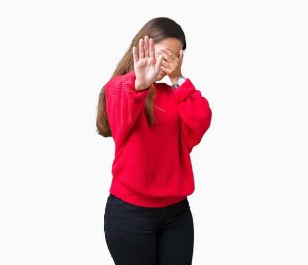 独立した背景の上に赤い冬のセーターを着て 手で目を覆い 悲しいと恐怖の表現でジェスチャーを止める若い美しいブルネットの女性 恥ずかしいと否定的な概念 — ストック写真