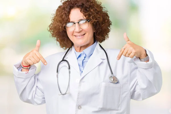 中年资深医生女子在孤立的背景下看起来自信 面带微笑 用手指自豪而快乐地指着自己 — 图库照片