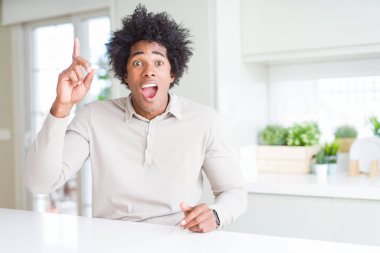 Afrika kökenli Amerikalı adam evde parmak ile başarılı fikir işaret. Çıktıktan ve mutlu. Bir numara.
