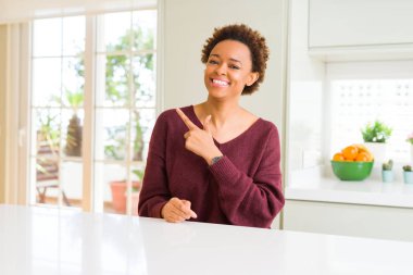 Genç güzel Afrikalı-Amerikalı kadın ve neşeli bir gülümseme yüzünü elimle işaret ile ev yan yüzünde mutlu ve doğal ifade ile kadar parmak