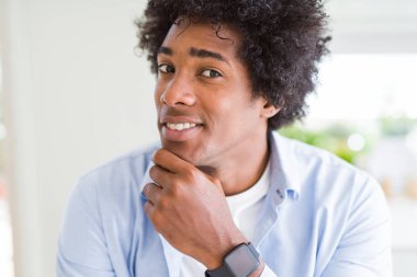 Çene düşünme hakkında soru, dalgın ifade üzerine el ile afro saçlı yakışıklı Afrikalı-Amerikalı adam. Düşünceli yüzüyle gülümsüyor. Şüphe kavramı.