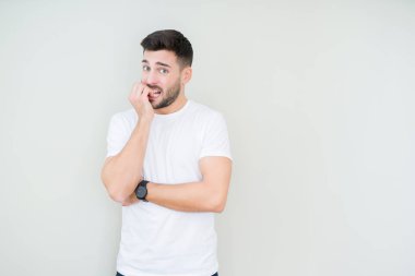 Genç yakışıklı adam stresli ve gergin ile izole arka plan üzerinde rahat beyaz t-shirt giyen tırnak ısırma dudaklarından eller. Anksiyete sorunu.