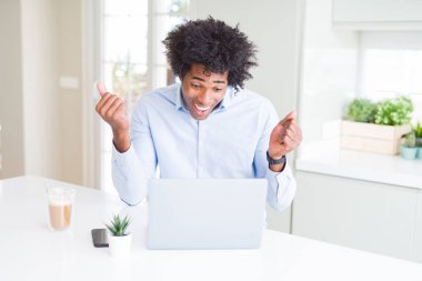 Afrika kökenli Amerikalı iş adamı gurur çığlık dizüstü kullanarak çalışma ve kutluyor zafer ve başarı çok heyecanlı, duygu tezahürat