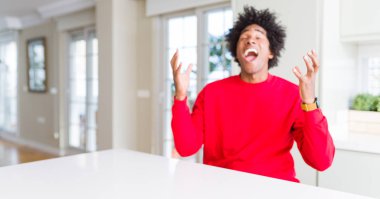 Afrika kökenli Amerikalı adam kızgın ve silah ile başarı için deli rahat kırmızı kazak kutluyor giyen kaldırdı ve heyecanlı çığlık gözler kapalı. Kazanan kavramı