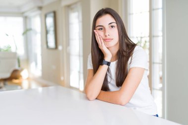 Beautiful young woman wearing casual white t-shirt thinking looking tired and bored with depression problems with crossed arms.