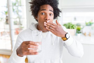 Afrika kökenli Amerikalı adam hata, korku, ifade için utanç ile kapak ağız el ile şok su evde içme sessizlik içinde gizli kavramı korkuttu