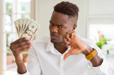 Öfkeli yüz ile yirmi dolar banka notları tutan Afrikalı Amerikalı adam, aşağı başparmak ile nefret gösteren negatif işareti, ret kavramı
