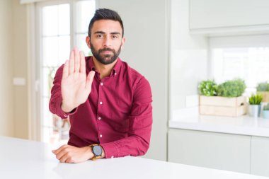 Yakışıklı İspanyol iş adamı el avuç ile şarkı durdurmak yapıyor. Yüz üzerinde negatif ve ciddi jest ile uyarı ifadesi.