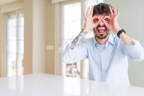 Joven Hombre Negocios Sentado Mesa Blanca Haciendo Buen Gesto Como —  Fotos de Stock