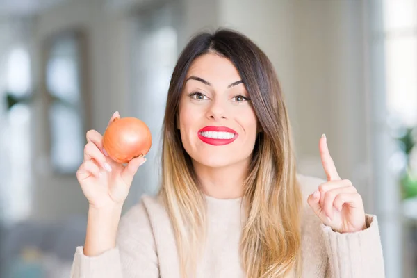 Joven Hermosa Mujer Sosteniendo Cebolla Fresca Casa Sorprendida Con Una — Foto de Stock