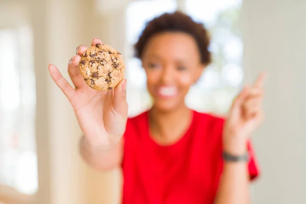 Junge Afroamerikanerin Isst Schokoladenkekse Sehr Glücklich Und Zeigt Mit Der — Stockfoto