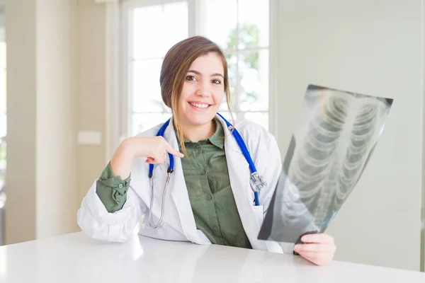 Hermosa Joven Médico Mujer Mirando Radiografía Pecho Con Cara Sorpresa —  Fotos de Stock