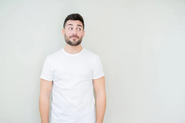 Mladý Pohledný Muž Nosí Ležérní Bílé Tričko Izolované Pozadí Vypadající — Stock fotografie