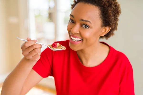 Young beautiful african american woman with afro hair eating hea — Stock Photo, Image