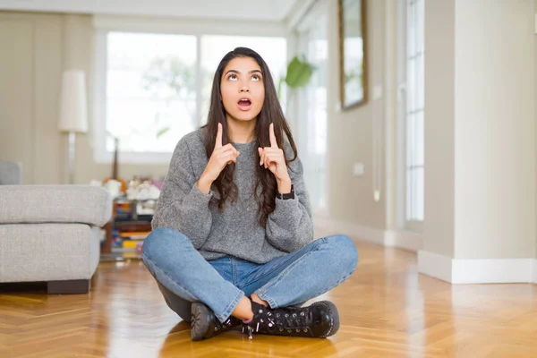 Joven Mujer Hermosa Sentada Suelo Casa Asombrada Sorprendida Mirando Hacia — Foto de Stock