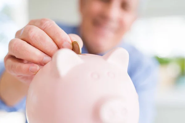 Man een munt binnen piggy bank zetten als spaargeld lachend confiden — Stockfoto