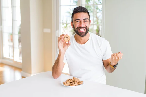 Όμορφος Ισπανόφωνος Άνθρωπος Τρώει Μπισκότα Τσιπ Σοκολάτας Ουρλιάζοντας Περήφανος Και — Φωτογραφία Αρχείου