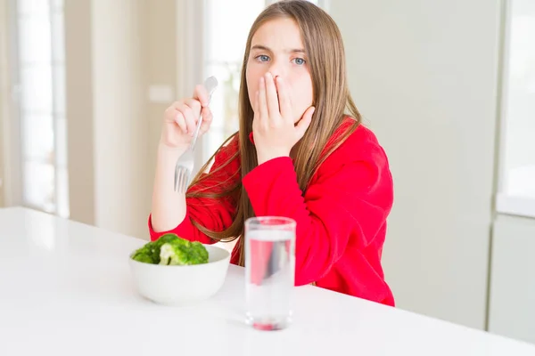 美しい若い女の子の子供は 新鮮なブロッコリーと飲料水を食べる手を使って ミスの恥 恐怖の表現 沈黙の中でおびえ 秘密の概念についてショックを受けました — ストック写真