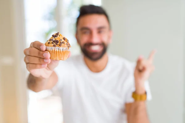 Hombre Hispano Guapo Comiendo Chips Chocolate Muffin Muy Feliz Señalando — Foto de Stock