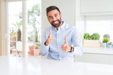 Yakışıklı İspanyol iş adamı mutlu ve komik yüz ile kamera parmaklar işaret. İyi enerji ve Vibes.