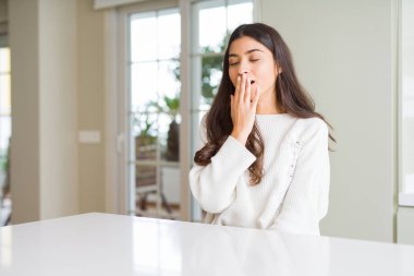 Beyaz masada evde genç güzel kadın el ile yorgun kaplayan ağız esneme sıkılmış. Huzursuz ve uykululuk.