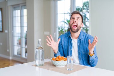 Yakışıklı adam yeme makarna köfte ve domates sosu evde çılgın ve kızgın bağırarak ve agresif ifade ve silah kaldırdı bağırıyordu. Hayal kırıklığı kavramı.