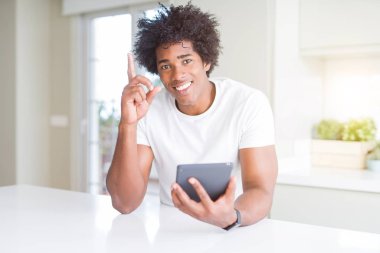 Afrika kökenli Amerikalı adam Touchpad tablo sürpriz bir fikir ya da soru işaret parmağı gülen yüz, bir numara ile kullanma