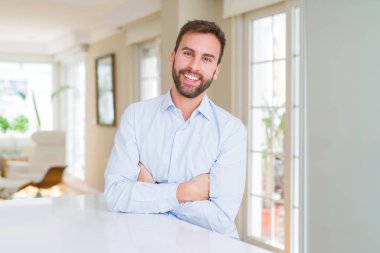 Yakışıklı iş adamı mutlu yüz çapraz silah kameraya bakarak ile gülümseyen. Olumlu bir kişi.