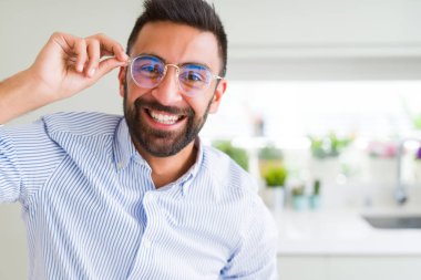 Gözlük takan ve yüz kendine güvenen gülümseme ile neşeli gülümseyen yakışıklı iş adam