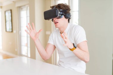 Genç adam eğleniyor evde sanal gerçeklik gözlüklü