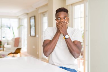 Afro-Amerikan yakışıklı beyaz tablo evde kapsayan ağız elle hata için şok. Gizli kavramı.