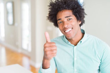 Afrika kökenli Amerikalı iş adamı mutlu Yaşasın el hareketini yaparken şık gömlek giymiş. Başarı gösteren kameraya bakarak ifade onaylama.