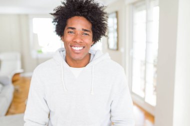 Afrika kökenli Amerikalı adam yüzünde mutlu ve güzel bir gülümseme ile kazak giyiyor. Şanslı kişi.