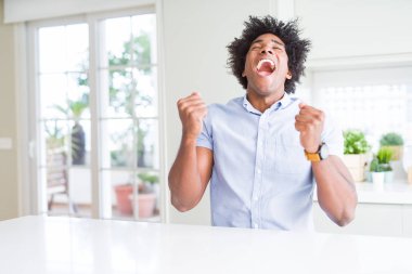 Gülümseyen ve başarı için çığlık Afrikalı-Amerikalı iş adamı çok mutlu ve heyecanlı kaldırdı, silah ile kazanan jest yapıyor. Kutlama kavramı.