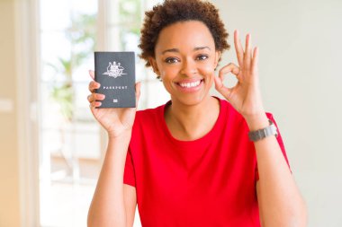 Avustralya pasaportu parmak, mükemmel sembolü ile ok işareti yapıyor tutan genç Afro-Amerikan kadın