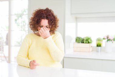 Güzel kadın kıdemli sarı kazak yorgun sürtünme burun ve göz yorgunluğu ve baş ağrısı hissediyor. Stres ve hayal kırıklığı kavramı.