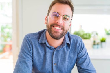 Gözlük takan ve gülümseyen yakışıklı adam kameraya rahat