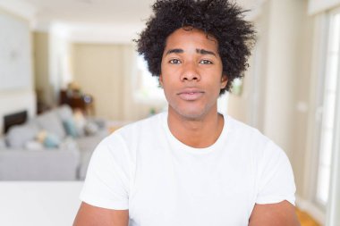 Yüzünde ciddi bir ifade ile Afrika kökenli Amerikalı adam evde rahat. Basit ve çapraz silah ile doğal