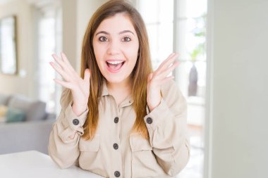 Güzel genç kadın evde çılgın ve başarı için hayran kaldırdı Kollarını açarak kutluyor ve heyecanlı çığlık gözleri açık. Kazanan kavramı