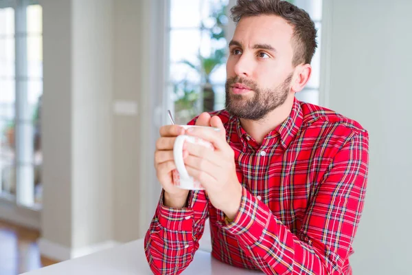 Hombre guapo bebiendo una taza de café en casa — Foto de Stock