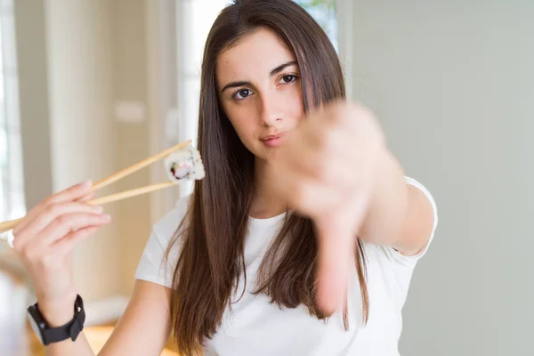 Hermosa Joven Comiendo Sushi Asiático Usando Palillos Con Cara Enojada — Foto de Stock