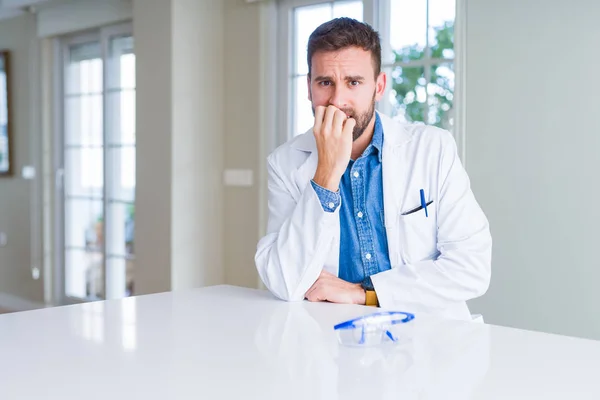 英俊的科学家男子穿着白色长袍和安全眼镜 看起来压力和紧张 手在嘴咬指甲 焦虑问题 — 图库照片