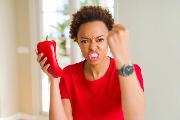 拿着新鲜红辣椒的年轻非洲裔美国女人愤怒和沮丧的喊声与愤怒 疯狂和大喊大叫与提高的手 愤怒的概念 — 图库照片