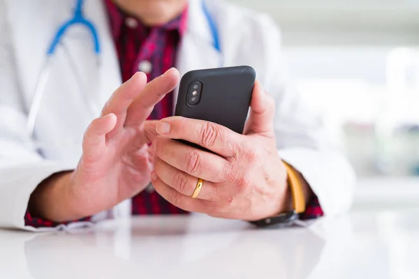 Close up of doctor man hands using smartphone and wearing stetho — Stock Photo, Image