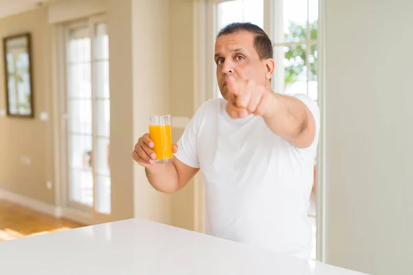 Hombre Mediana Edad Bebiendo Vaso Jugo Naranja Casa Señalando Con —  Fotos de Stock
