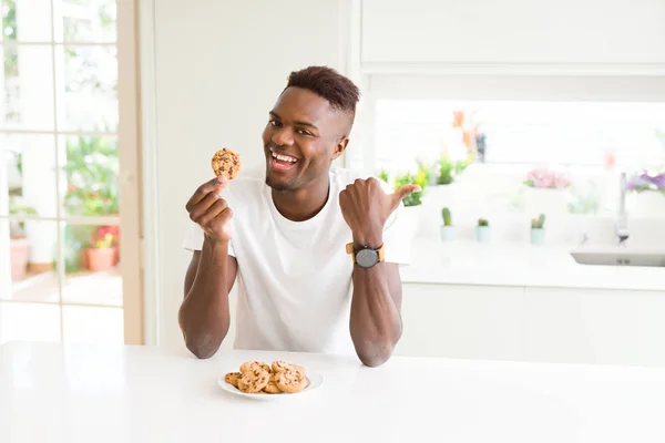 Mladý Američan Afričana Muž Jíst Čokoládu Čipy Soubory Cookie Ukazující — Stock fotografie