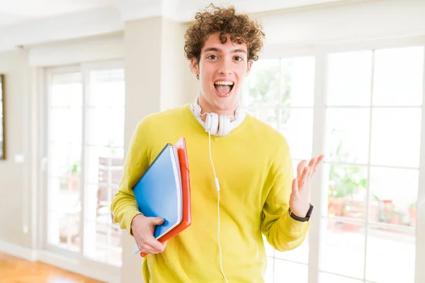 Człowiek Młody Student Noszenia Słuchawek Trzyma Notebooki Bardzo Szczęśliwy Podekscytowany — Zdjęcie stockowe