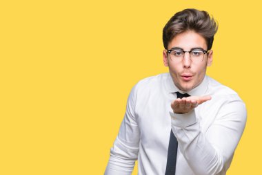 Bir öpücük el ile güzel ve seksi olmak hava üfleme kamera bakarak izole arka plan üzerinde gözlük takan genç iş adamı. Aşk ifade.